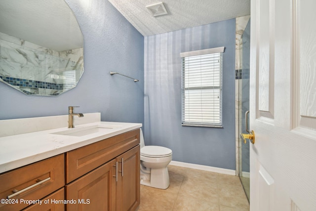 bathroom featuring walk in shower, vanity, a textured ceiling, tile patterned flooring, and toilet