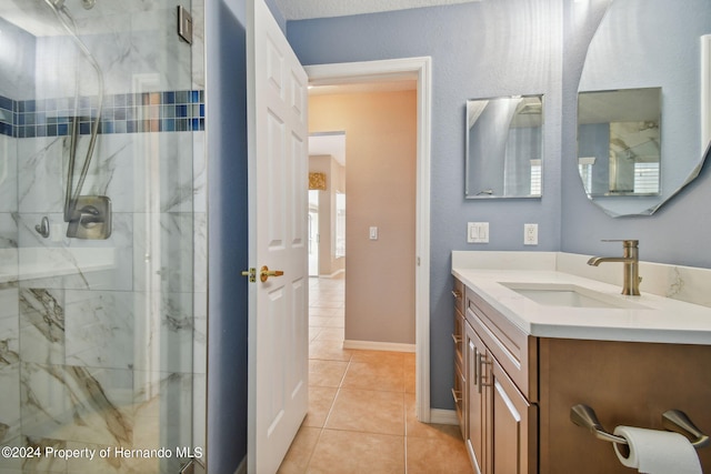 bathroom with walk in shower, vanity, and tile patterned flooring