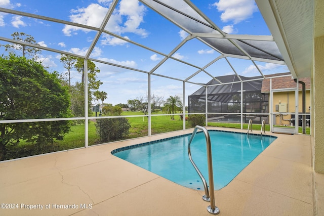 view of swimming pool with glass enclosure and a patio