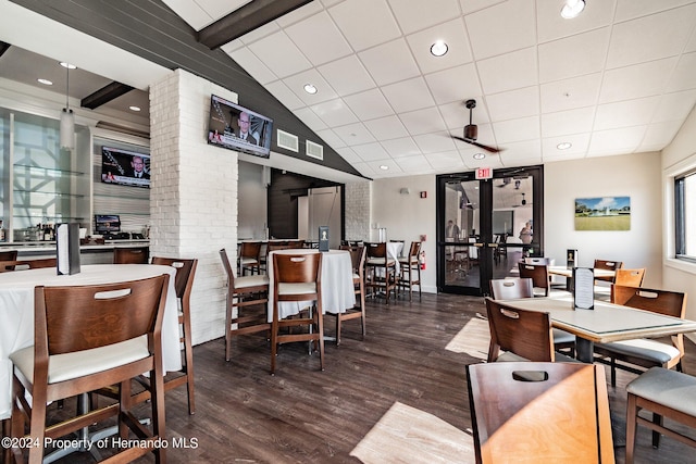 dining space featuring lofted ceiling with beams and dark hardwood / wood-style floors