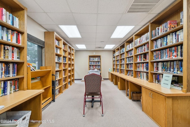 office area with a paneled ceiling and light carpet