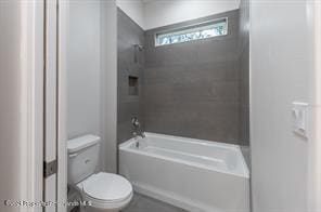 bathroom featuring toilet and tiled shower / bath