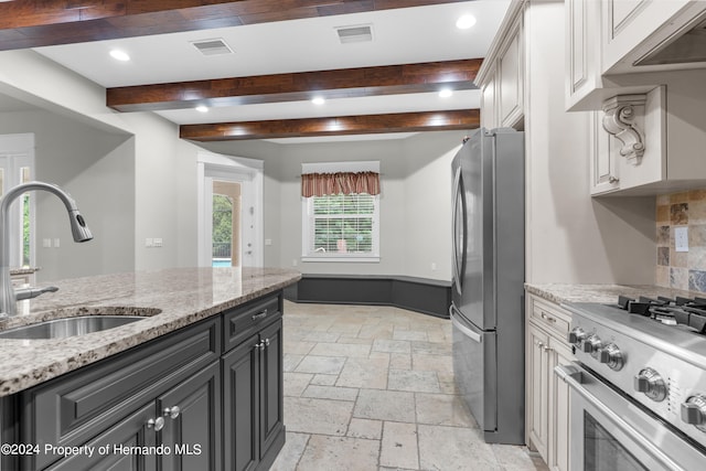 kitchen with stainless steel appliances, sink, and light stone counters