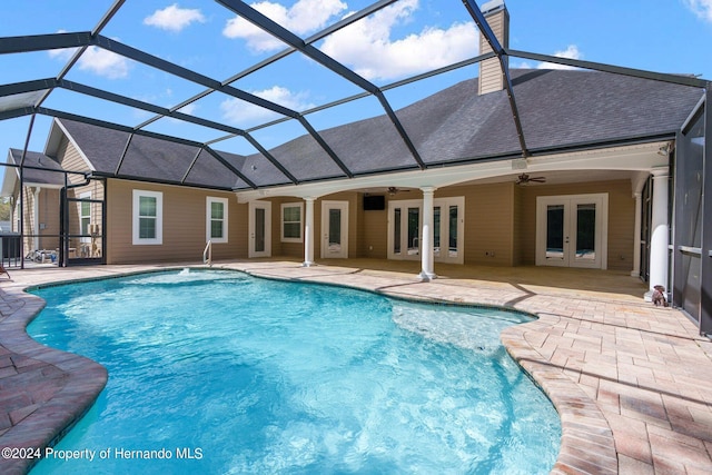 view of swimming pool with a patio, ceiling fan, glass enclosure, and french doors