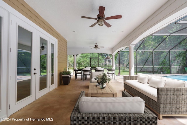 view of patio featuring glass enclosure, french doors, an outdoor hangout area, and ceiling fan