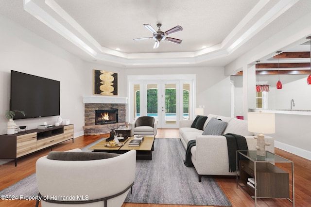 living room with french doors, wood-type flooring, and a tray ceiling