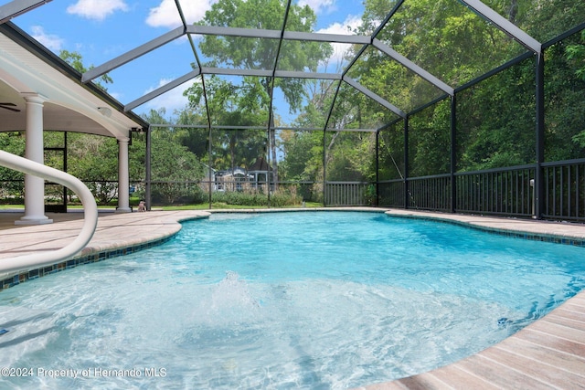 view of swimming pool featuring glass enclosure