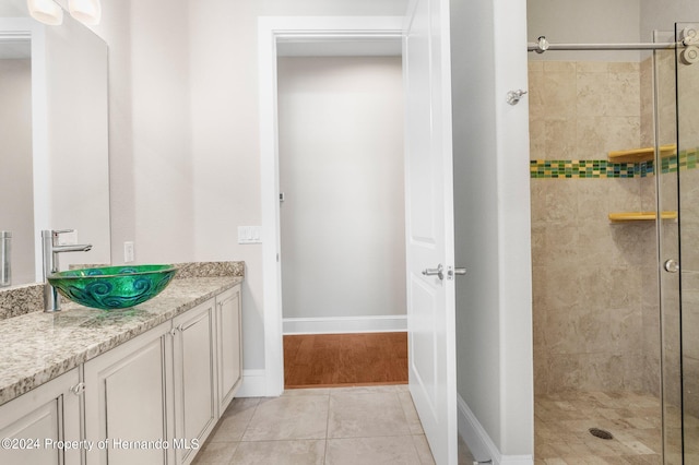 bathroom featuring vanity, tile patterned flooring, and a tile shower