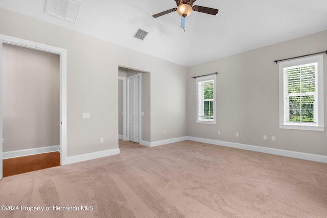 unfurnished bedroom featuring light colored carpet, multiple windows, and ceiling fan