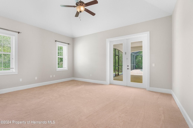 empty room with french doors, light colored carpet, and ceiling fan