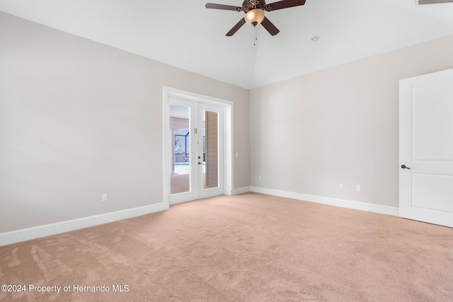 empty room featuring french doors, lofted ceiling, light carpet, and ceiling fan