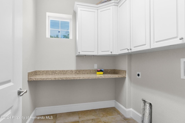 laundry room featuring electric dryer hookup and cabinets