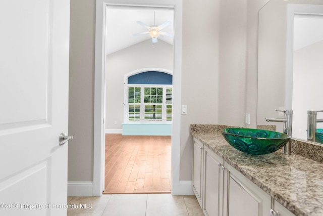 bathroom featuring hardwood / wood-style floors, lofted ceiling, ceiling fan, and vanity