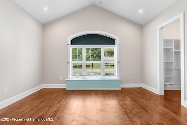 spare room featuring lofted ceiling and hardwood / wood-style floors