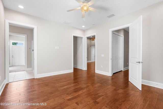 unfurnished bedroom with hardwood / wood-style flooring, ceiling fan, and a closet