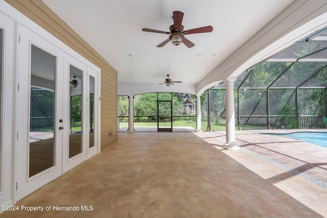 view of patio / terrace with ceiling fan, a lanai, and french doors