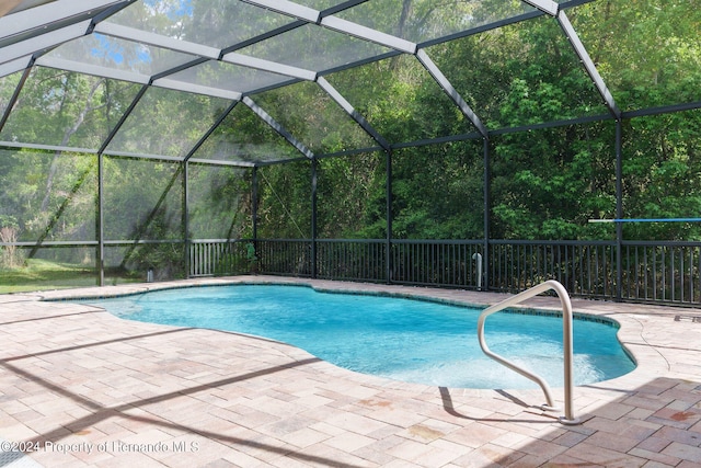 view of pool featuring glass enclosure and a patio area