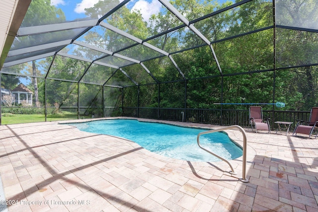 view of swimming pool with a patio and glass enclosure