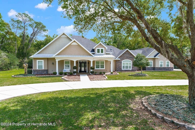 craftsman inspired home featuring a front lawn and covered porch