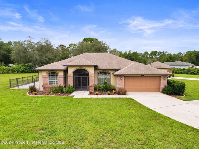 view of front of home with a garage and a front lawn