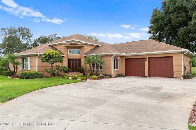 view of front of house with a front lawn, a garage, and french doors