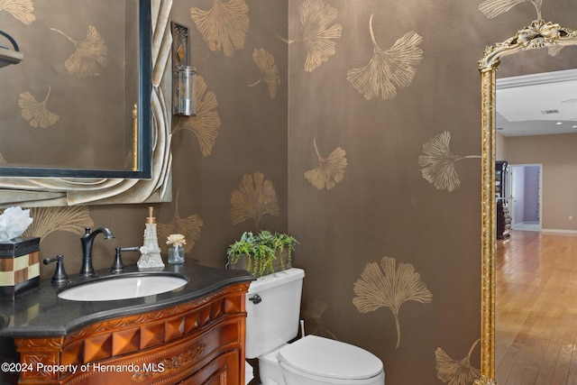 bathroom with wood-type flooring, vanity, and toilet