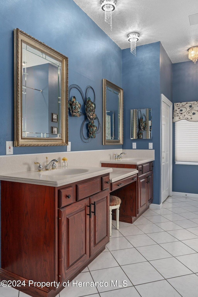 bathroom featuring vanity, a chandelier, a textured ceiling, and tile patterned floors