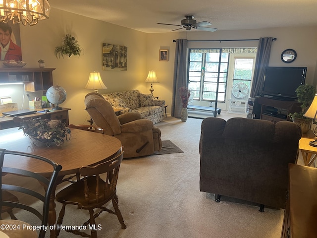 carpeted living room with ceiling fan with notable chandelier