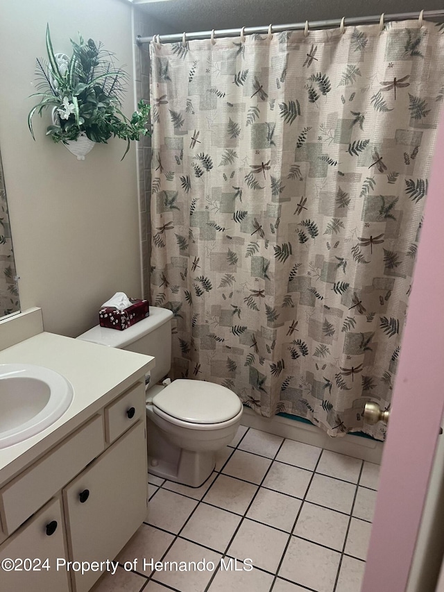 bathroom featuring toilet, vanity, tile patterned flooring, and walk in shower