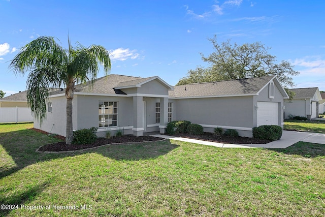 ranch-style home featuring a garage and a front lawn