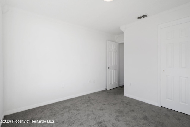 unfurnished bedroom featuring crown molding and carpet