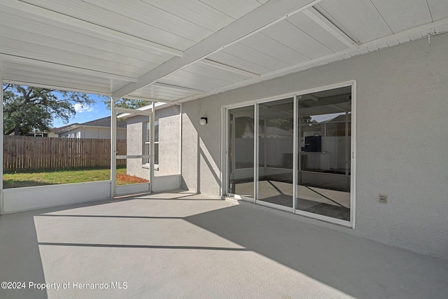 unfurnished sunroom with beam ceiling