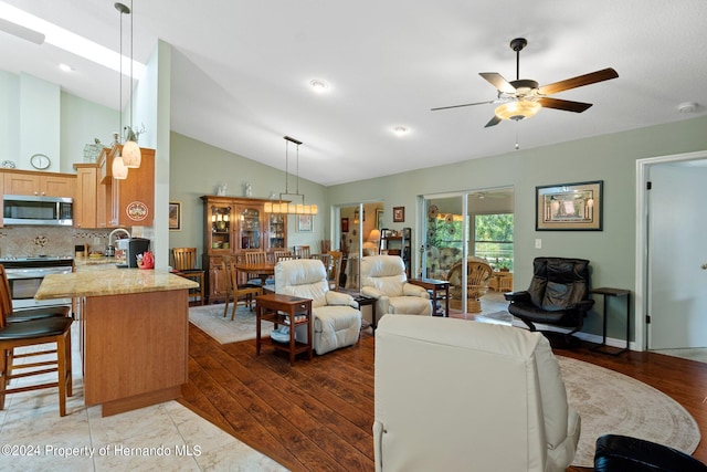 living room with dark wood-type flooring, ceiling fan, and lofted ceiling