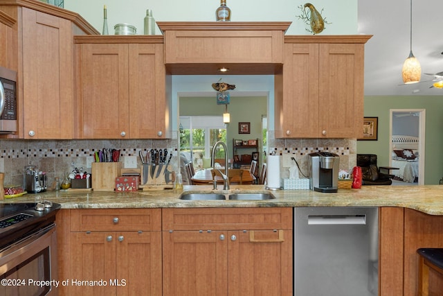 kitchen featuring hanging light fixtures, sink, appliances with stainless steel finishes, and tasteful backsplash