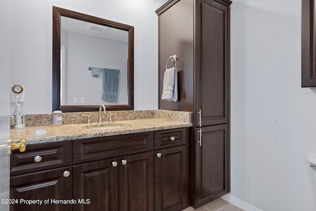 bathroom featuring tile patterned flooring, vanity, and toilet