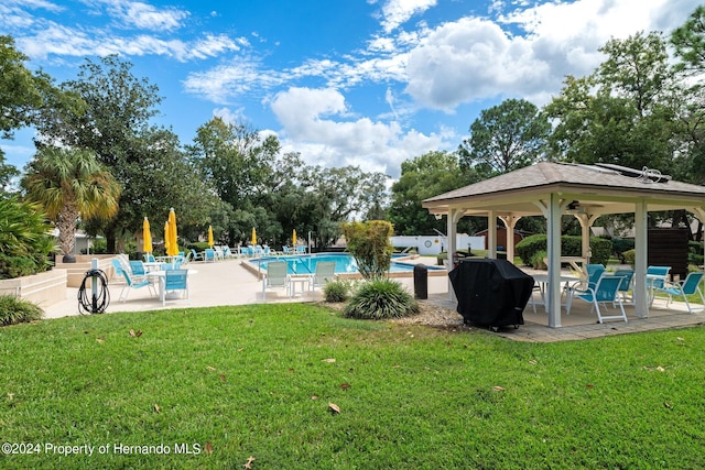 view of pool with a grill, a lawn, and a patio