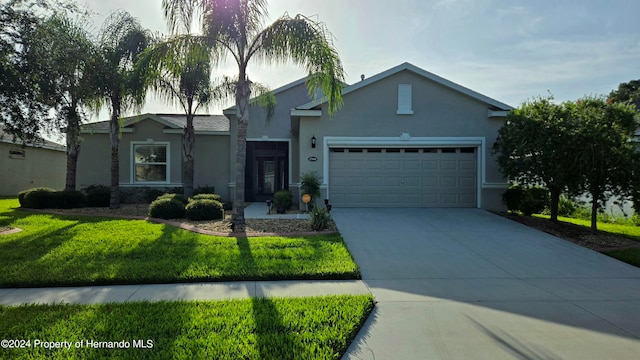 single story home featuring a garage and a front lawn