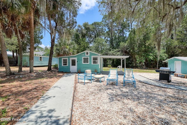 back of house featuring a storage shed