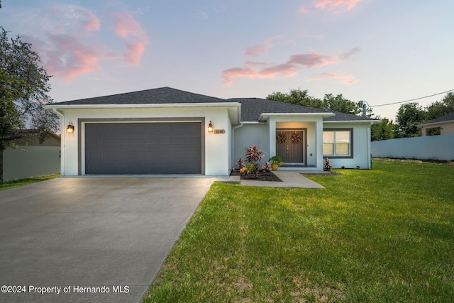 view of front facade with a garage and a lawn