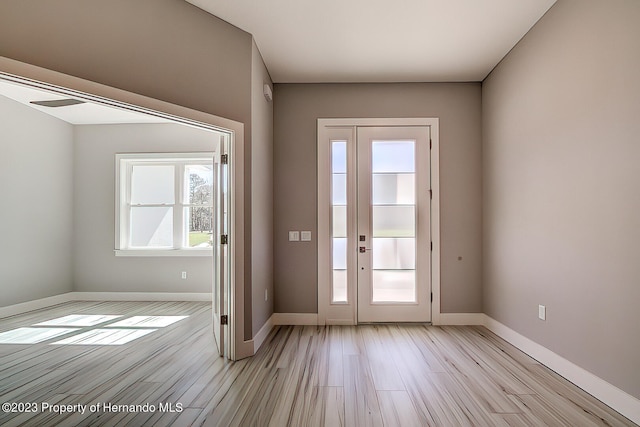 entryway with light hardwood / wood-style floors and a healthy amount of sunlight