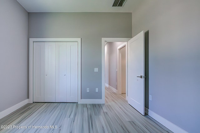 unfurnished bedroom with a closet and light hardwood / wood-style flooring