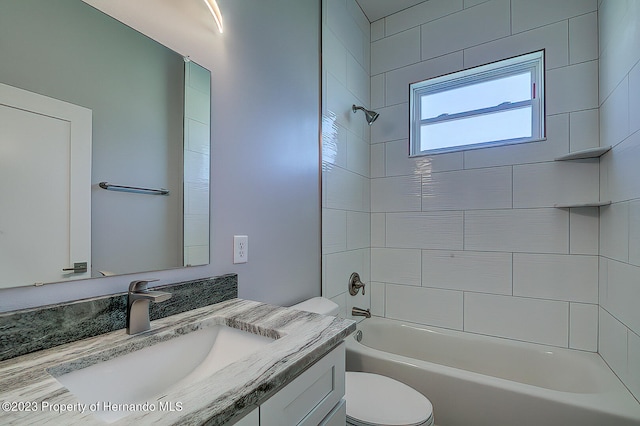 full bathroom featuring vanity, tiled shower / bath combo, and toilet