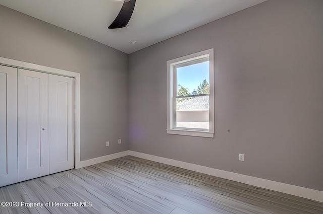 unfurnished bedroom with a closet, ceiling fan, and light hardwood / wood-style flooring