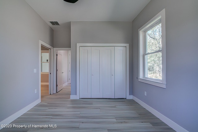 unfurnished bedroom with a closet and light hardwood / wood-style flooring