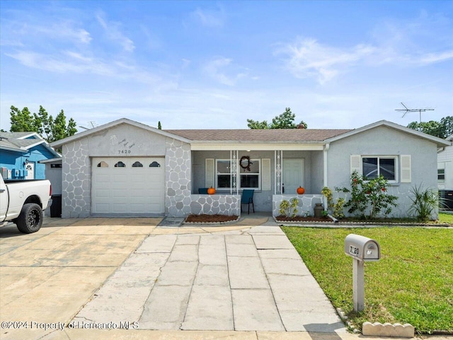 single story home featuring covered porch, a garage, and a front lawn