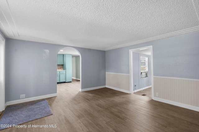 spare room with hardwood / wood-style floors and a textured ceiling