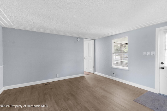 spare room featuring a textured ceiling and hardwood / wood-style flooring