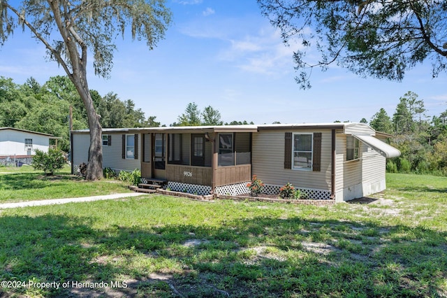 manufactured / mobile home featuring a front yard and a sunroom