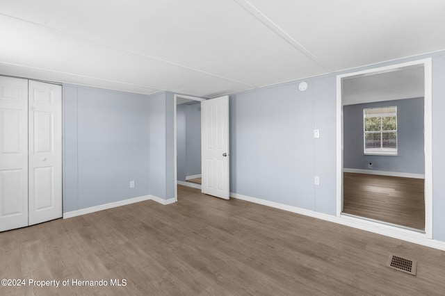 unfurnished bedroom featuring wood-type flooring and a closet