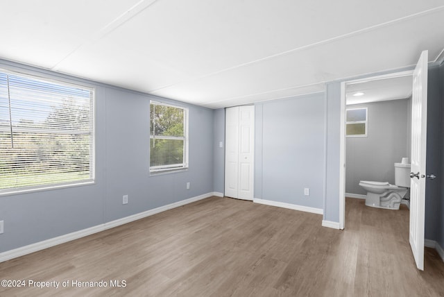 unfurnished bedroom with light wood-type flooring and a closet